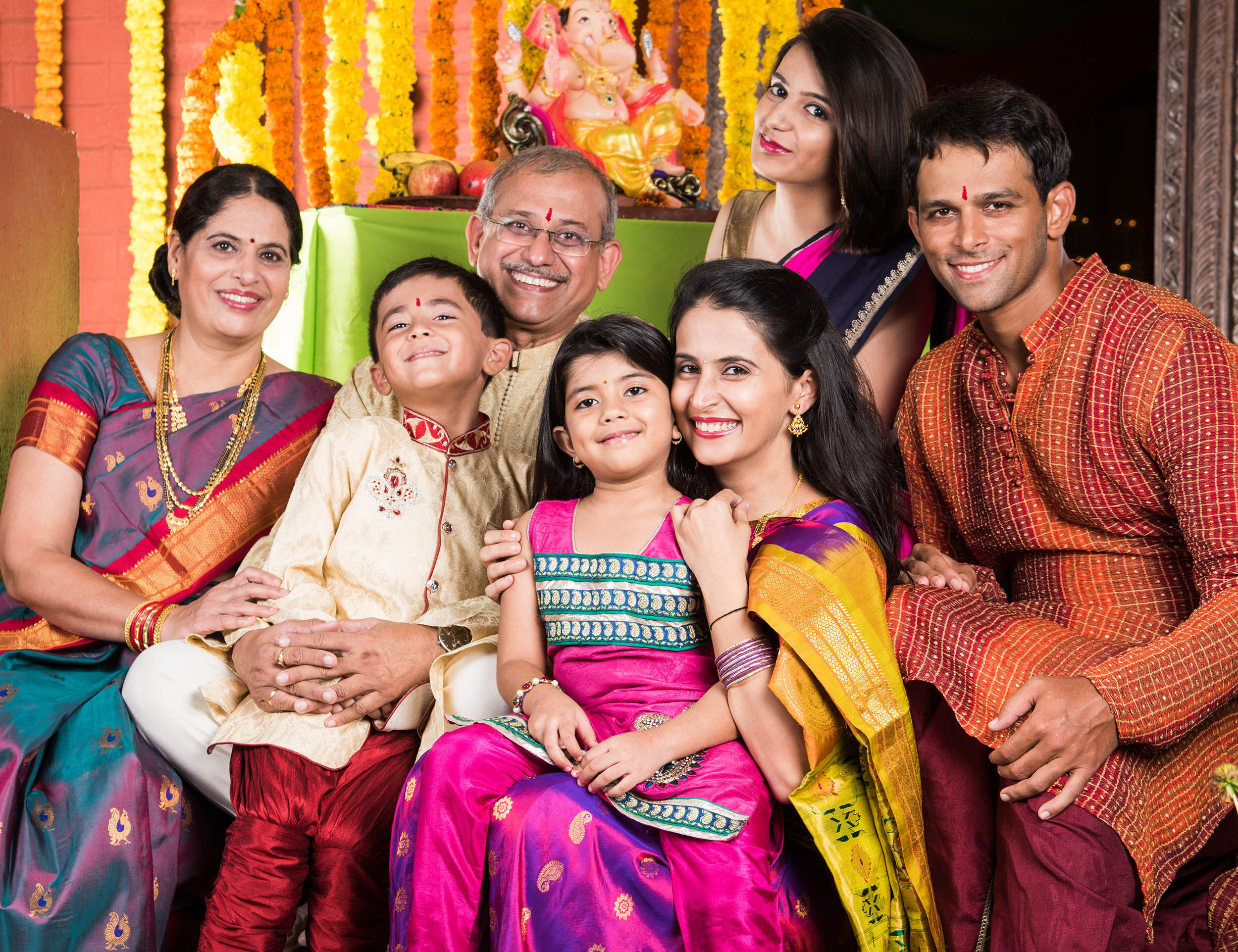 A joyful family dressed in stylish party wear, celebrating together at a post-wedding event.